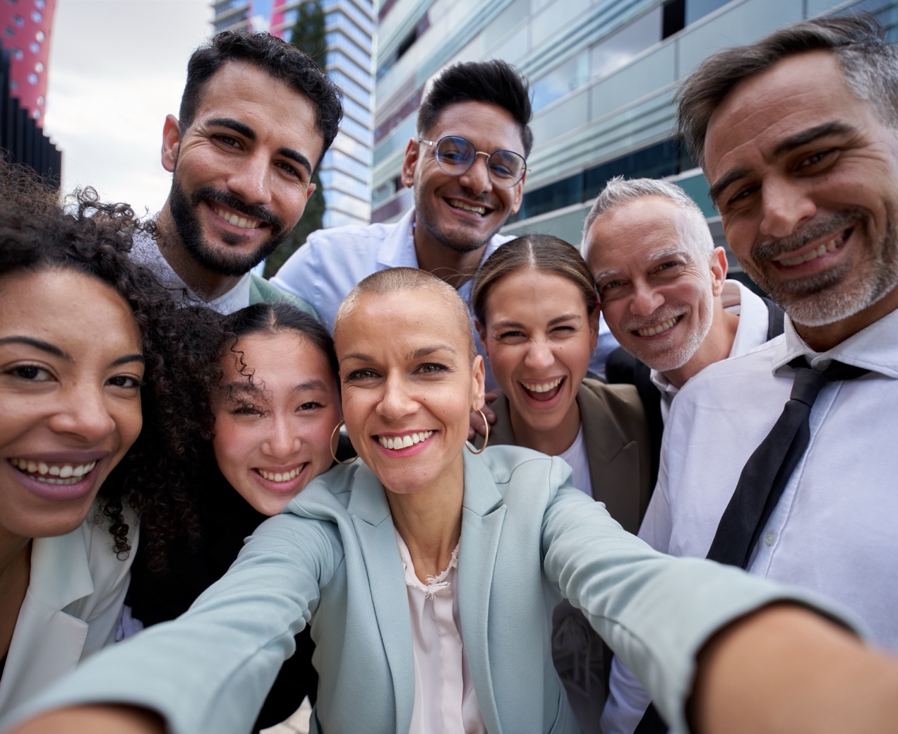 High-volume team taking a group selfie outside their office